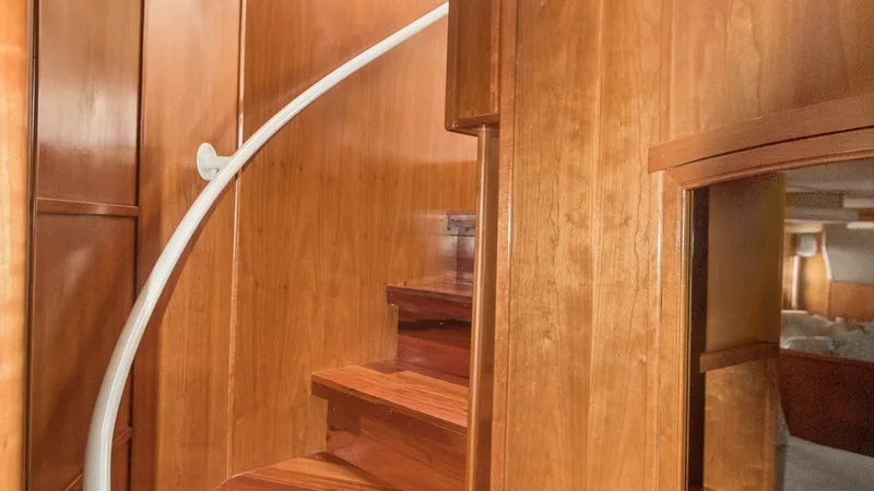 Slide: The Image of Elegant Interior Staircase This image showcases the elegant staircase of the 2005 Meridian 540 Pilothouse, featuring rich wooden finishes that add warmth and sophistication. The curved design and smooth handrail enhance both safety and style, leading seamlessly to the upper levels. - 7721614