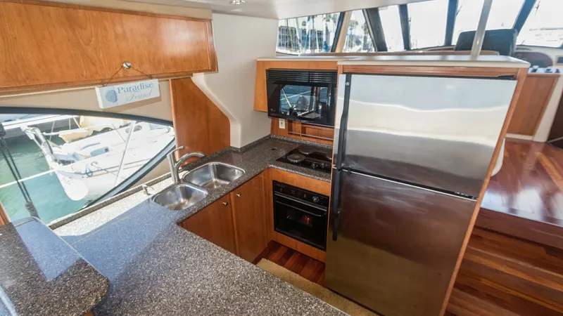Slide: The Image of Galley with Stainless Steel Appliances This stylish galley on the Meridian 540 Pilothouse features modern stainless steel appliances, including a large refrigerator and built-in microwave. The dual sink setup and ample countertop space provide functionality and convenience for meal preparation - 7721598