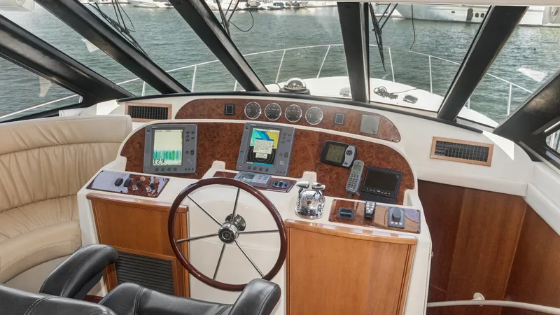 Slide: The Image of Helm Station with Electronics The helm station of the Meridian 540 Pilothouse features a well-appointed control panel with integrated navigation systems and classic wood finishes. The leather captain's chair provides comfort, while the expansive windows offer excellent visibility. Thi - 7721594