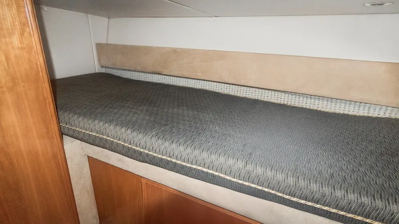 Slide: The Image of Guest Cabin Twin Berth This cozy guest cabin features a comfortable twin berth with a sleek upholstered headboard, ideal for restful nights at sea. The warm wood finishes and neutral tones create an inviting atmosphere, complemented by ample under-berth storage. Perfect for acc - 7721616
