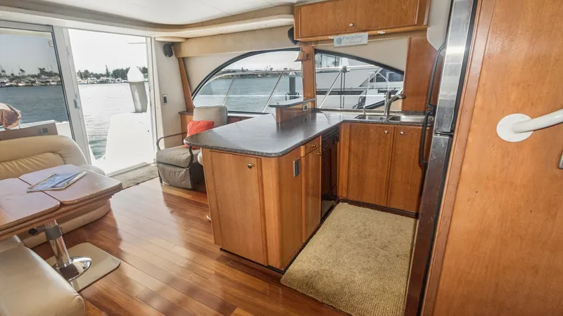 Slide: The Image of Spacious Galley with Water Views This inviting galley on the 2005 Meridian 540 Pilothouse features elegant wood cabinetry and ample countertop space, perfect for preparing meals while enjoying panoramic water views. The open layout seamlessly connects to the salon area, allowing for easy - 7721592
