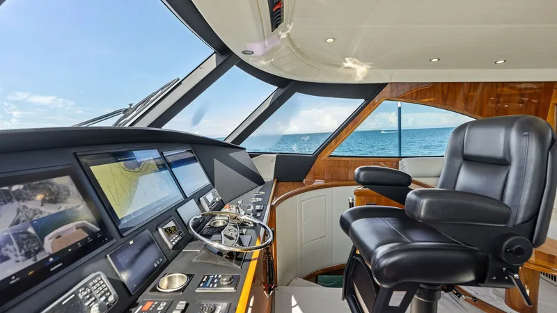 Slide: The Image of Enclosed Bridge Helm Station The enclosed bridge of the Viking 62 offers a state-of-the-art helm station with panoramic ocean views. Featuring advanced navigation systems and luxurious seating, this space combines functionality with comfort for extended voyages. The sleek dashboard a - 7751273