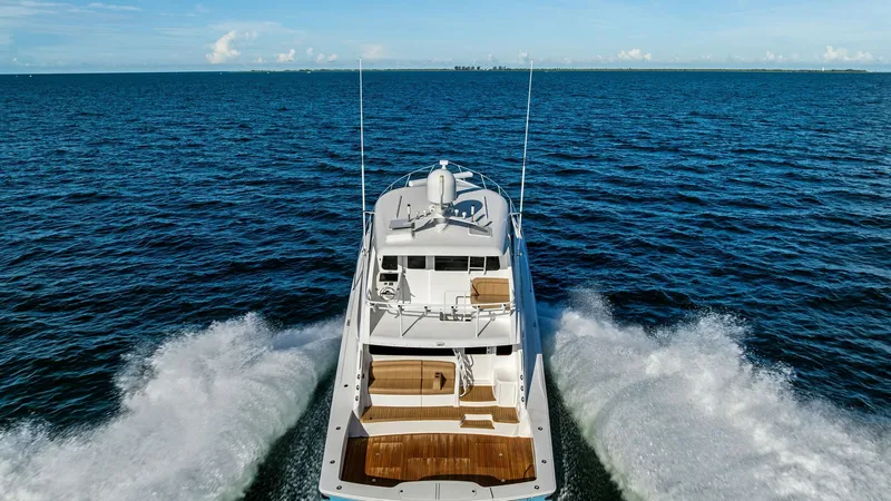 Slide: The Image of Aerial View of Aft Deck in Motion This dynamic aerial shot captures the Viking 62 Enclosed Bridge, emphasizing its sleek aft deck and powerful wake. The spacious teak-finished deck offers ample room for relaxation and activities, complemented by the elegant enclosed bridge above. The vess - 7751316