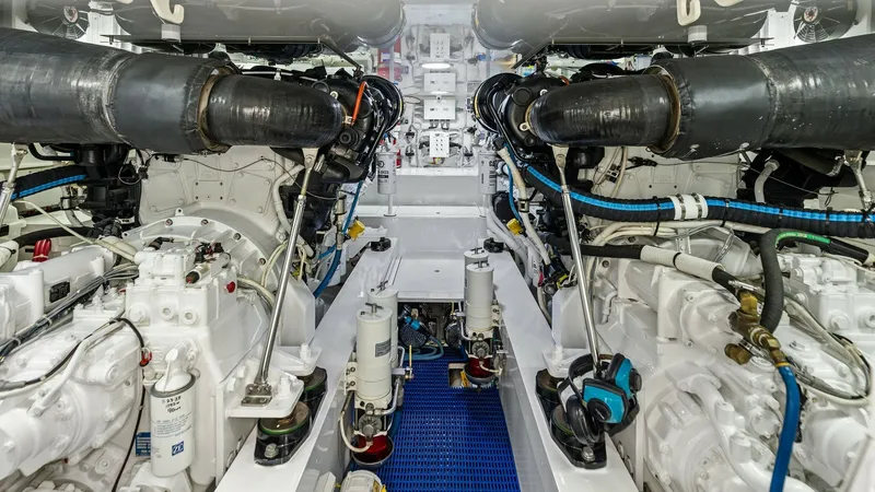 Slide: The Image of Engine Room Overview The engine room of the 2018 Viking 62 Enclosed Bridge showcases a meticulously organized space with dual powerful engines, designed for optimal performance. The clean layout features well-labeled components and accessible pathways, ensuring easy maintenan - 7751290