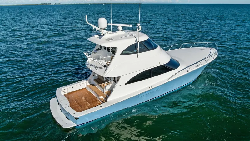 Slide: The Image of Aerial View of Enclosed Bridge Yacht This stunning aerial view showcases the sleek design of the 2018 Viking 62 Enclosed Bridge, 'Joan's Boys'. The yacht features a spacious aft deck with elegant teak flooring, perfect for outdoor leisure and entertaining. The enclosed bridge offers a stream - 7751310