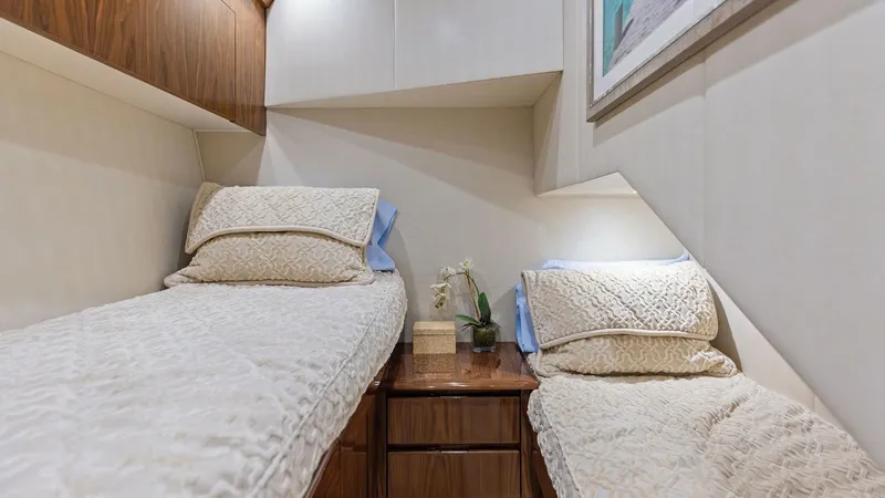 Slide: The Image of Twin Guest Stateroom This cozy twin guest stateroom features elegantly upholstered walls and warm wood accents, creating a welcoming atmosphere. The room is thoughtfully designed with two single beds separated by a sleek, built-in nightstand. Soft, ambient lighting enhances t - 7751268