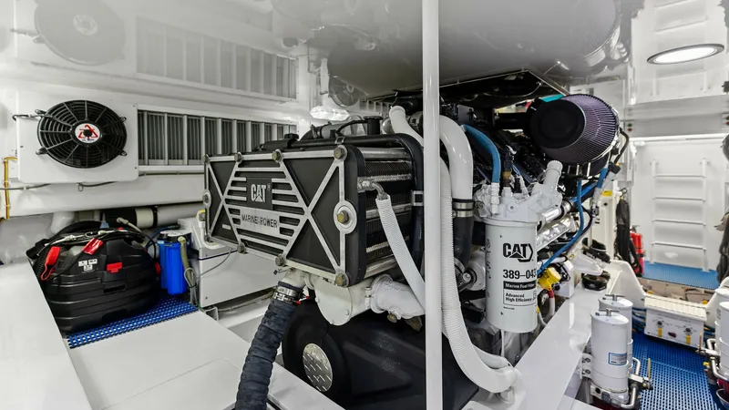 Slide: The Image of Engine Room with CAT Power This image showcases the meticulously maintained engine room of the Viking 62 Enclosed Bridge, featuring powerful CAT marine engines. The space is impeccably organized, highlighting the vessel's commitment to performance and reliability. Bright lighting a - 7751297