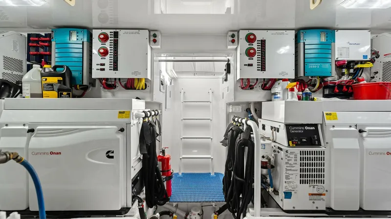 Slide: The Image of Engine Room with Electrical Panels This image showcases the well-organized engine room of the Viking 62 Enclosed Bridge. Featuring dual Cummins Onan generators, the space is equipped with modern electrical panels and wiring systems for optimal efficiency. The room's bright lighting and cle - 7751300