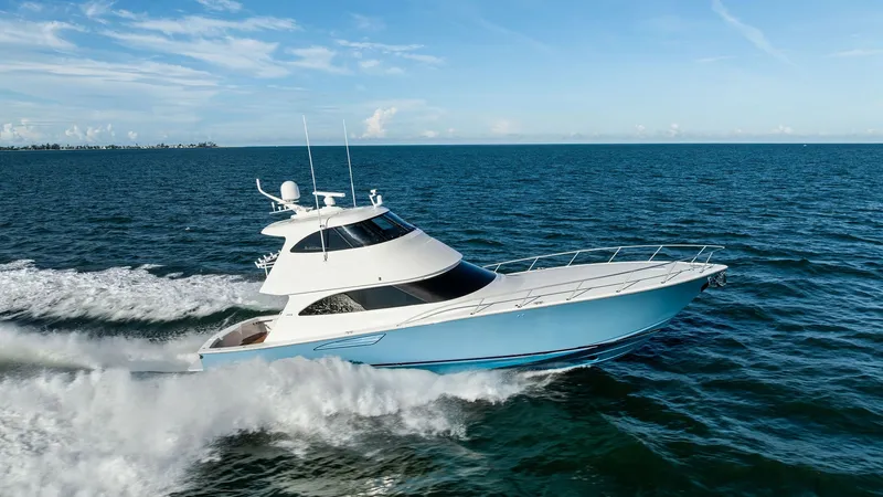 Slide: The Image of Side Profile of Viking 62 Enclosed Bridge The Viking 62 Enclosed Bridge, 'Joan's Boys', showcases its sleek and powerful design as it glides effortlessly through the water. The vessel's striking blue hull complements its aerodynamic enclosed bridge, providing superior visibility and comfort. The - 7751320