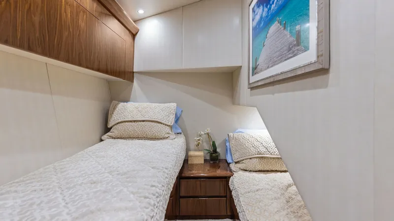 Slide: The Image of Guest Stateroom with Twin Berths This cozy guest stateroom features twin berths adorned with plush bedding, providing comfort and style. The space is enhanced by rich wood cabinetry and soft ambient lighting, creating a warm and inviting atmosphere. A tasteful piece of artwork adds a tou - 7751270