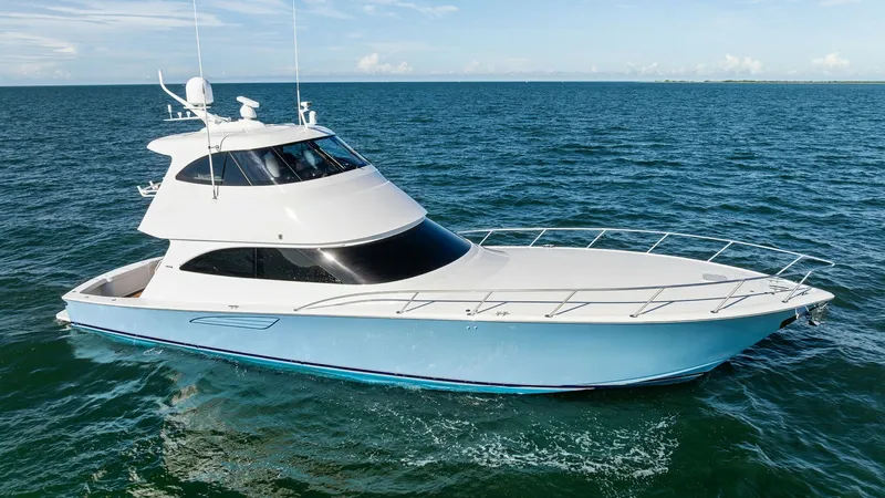 Slide: The Image of Aerial View of Enclosed Bridge This image showcases the sleek profile of the 2018 Viking 62 Enclosed Bridge, 'Joan's Boys'. The yacht's aerodynamic design is complemented by its spacious enclosed bridge, offering panoramic views and protection from the elements. The striking hull featu - 7751308