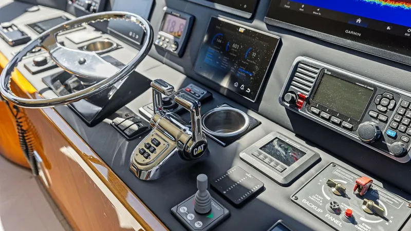 Slide: The Image of Helm Console with Navigation Displays The helm console of the Viking 62 Enclosed Bridge showcases a sophisticated array of navigation and control systems. Prominent features include multiple high-resolution displays for navigation and system monitoring, alongside an ergonomic steering wheel a - 7751279