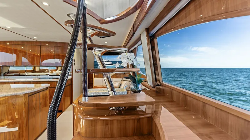 Slide: The Image of Interior Staircase with Ocean View This elegant interior staircase on the Viking 62 Enclosed Bridge features polished wood finishes and a sleek, modern design. Large windows provide breathtaking ocean views, enhancing the luxurious atmosphere. The craftsmanship and attention to detail in t - 7751221