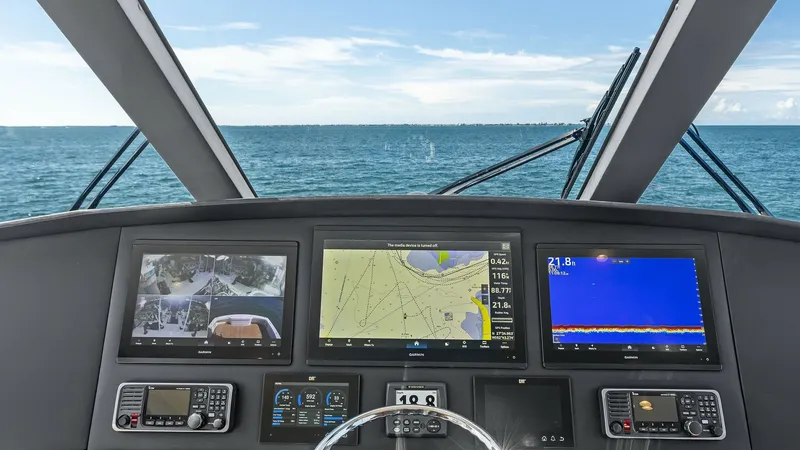 Slide: The Image of Enclosed Bridge Helm Station The helm station on the Viking 62 Enclosed Bridge offers a panoramic view of the open sea. Equipped with state-of-the-art navigation systems, it features multiple high-resolution displays for chart plotting, radar, and sonar. The ergonomic design and adva - 7751277
