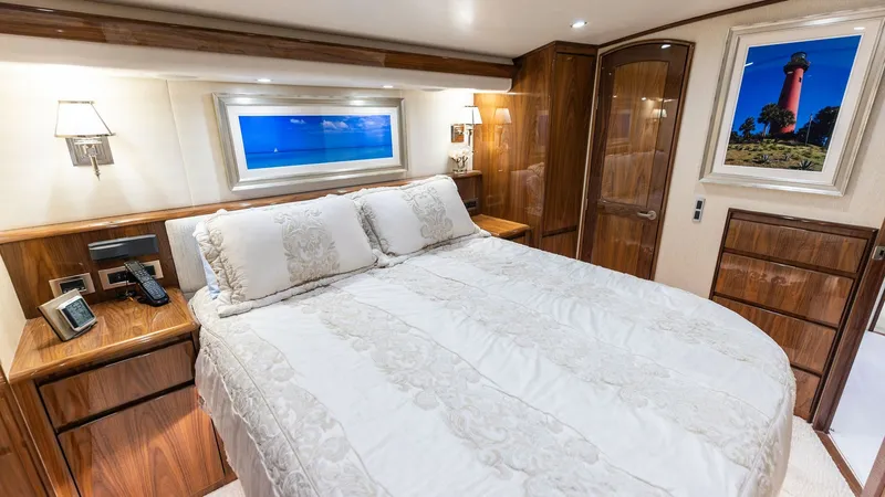 Slide: The Image of Luxurious Master Stateroom Interior This master stateroom features a plush queen-sized bed with elegant linens, offering a comfortable retreat. Rich wood finishes and ambient lighting create a warm and inviting atmosphere. The room is complemented by ample storage space and an artfully fram - 7751240
