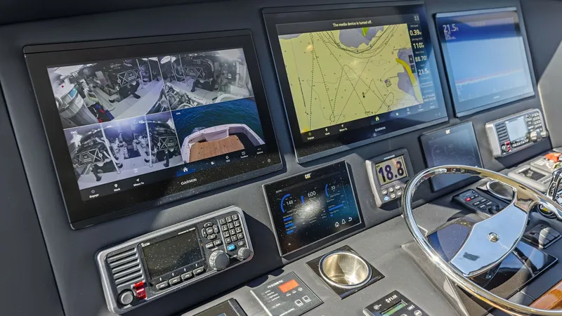 Slide: The Image of Helm Station with Advanced Electronics The helm station of the 2018 Viking 62 Enclosed Bridge features state-of-the-art navigation and monitoring systems. Multiple screens display navigational charts, radar, and camera feeds, ensuring a comprehensive view of the vessel's surroundings. The mode - 7751278