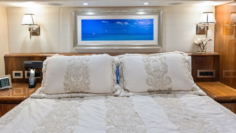 Slide: The Image of Luxurious Master Stateroom This master stateroom aboard the 2018 Viking 62 Enclosed Bridge exudes elegance with its plush bedding and rich wood finishes. The room features ambient recessed lighting and stylish wall sconces, creating a warm and inviting atmosphere. A large window ab - 7751238