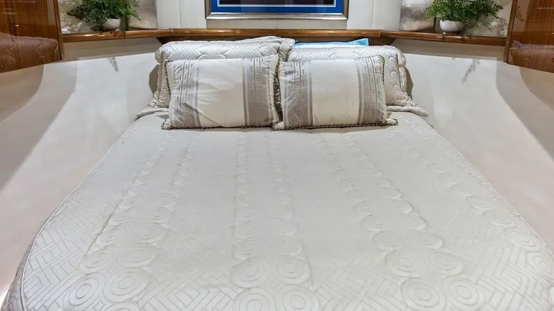 Slide: The Image of Luxurious Forward Stateroom This elegant forward stateroom on the 2018 Viking 62 Enclosed Bridge features a plush queen-sized berth with exquisite bedding. The space is adorned with rich wood cabinetry and soft ambient lighting, creating a warm and inviting atmosphere. Decorative pl - 7751250