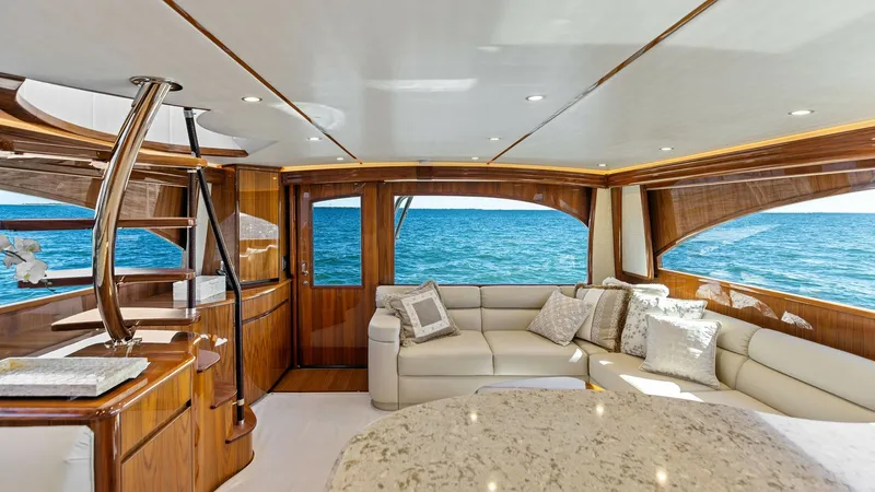Slide: The Image of Salon with Ocean Views The salon of the Joan's Boys Viking 62 Enclosed Bridge offers luxurious comfort with a plush L-shaped sofa and elegant wood finishes. Expansive windows provide stunning ocean views, enhancing the spacious feel of the interior. The stylish design is comple - 7751225