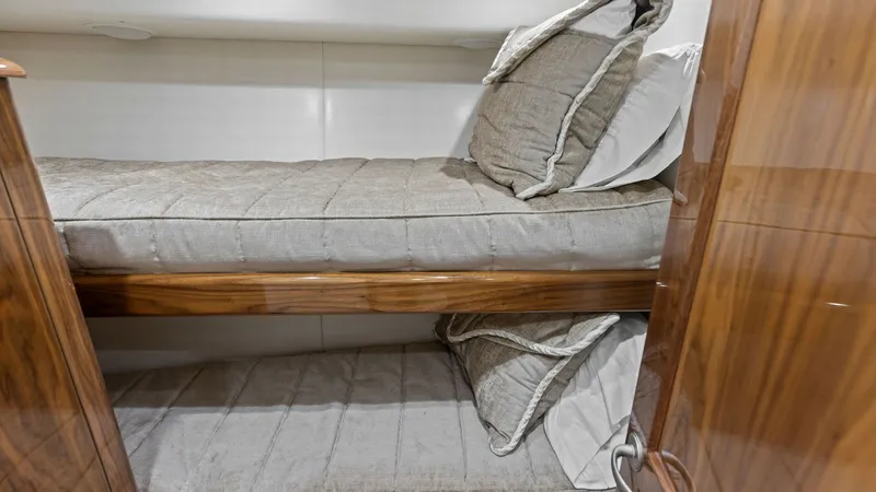 Slide: The Image of Cozy Twin Bunk Cabin This intimate cabin features twin bunks, offering a comfortable retreat with plush bedding and sleek wooden finishes. The warm tones of the wood paneling create a welcoming atmosphere, complemented by soft, ambient lighting. Ideal for guests seeking a res - 7751258