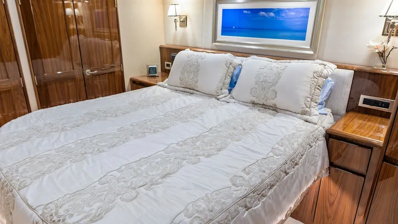 Slide: The Image of Master Stateroom with Luxurious Bedding The master stateroom of the 2018 Viking 62 Enclosed Bridge exudes elegance with its plush bedding and rich wood finishes. Soft ambient lighting and stylish wall sconces create a warm and inviting atmosphere. The room features ample storage and a soothing - 7751236