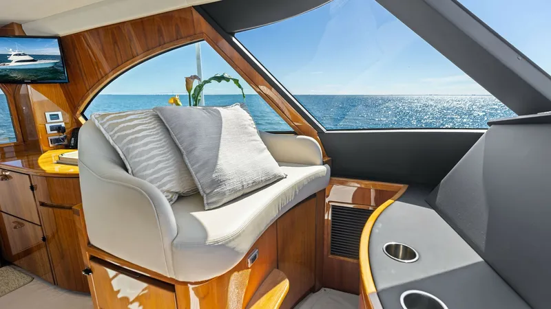 Slide: The Image of Enclosed Bridge Seating Area The enclosed bridge of the Viking 62 features a plush seating area with panoramic ocean views, ideal for relaxation. Elegant wood finishes and modern accents enhance the luxurious ambiance. Large windows flood the space with natural light, creating an inv - 7751275