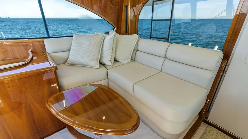 Slide: The Image of Enclosed Bridge Lounge Area This inviting lounge area in the Viking 62 Enclosed Bridge features plush, cream-colored seating, perfect for relaxation and socializing. The high-gloss wooden table complements the luxurious finishes, while large windows offer panoramic ocean views, enha - 7751281