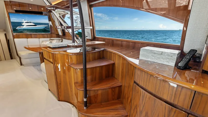 Slide: The Image of Enclosed Bridge with Ocean View The enclosed bridge of the 2018 Viking 62 features luxurious wood finishes, creating a warm and inviting ambiance. Large windows offer panoramic views of the ocean, enhancing the open, airy feel. A comfortable seating area and state-of-the-art controls en - 7751220