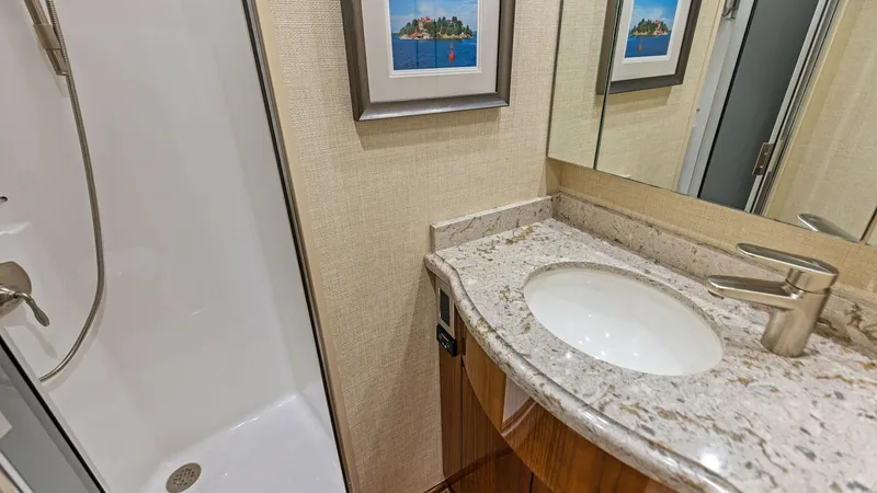 Slide: The Image of Elegant Guest Bathroom This refined guest bathroom features a modern design with a polished granite countertop and sleek fixtures, providing a touch of luxury. The enclosed shower is complemented by tasteful wall art, enhancing the space's inviting ambiance. High-quality materi - 7751254