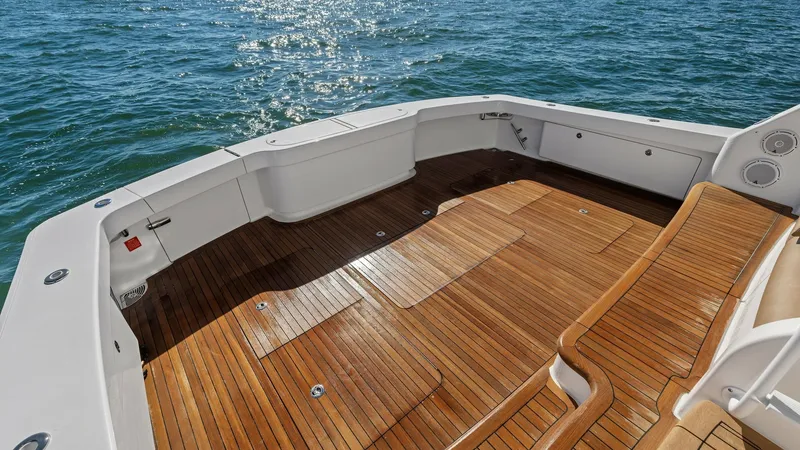 Slide: The Image of Spacious Teak Cockpit Area The cockpit of the 2018 Viking 62 Enclosed Bridge, 'Joan's Boys,' features a beautifully finished teak deck offering ample space for fishing or relaxation. The sleek design includes integrated storage compartments and rod holders, ideal for avid anglers. - 7751214
