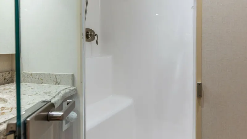 Slide: The Image of Elegant Enclosed Shower Stall This pristine shower stall on the Viking 62 Enclosed Bridge offers a luxurious and functional bathing space. The sleek design features a smooth, white finish complemented by high-quality fixtures. The adjacent granite countertop adds a touch of elegance, - 7751246
