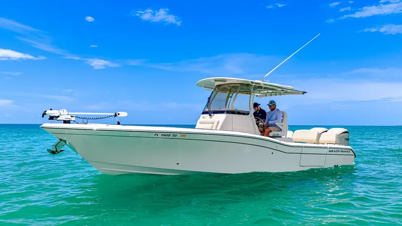 Slide: The Image of Grady-White 281 CE Side View This image showcases the sleek profile of the 2024 Grady-White 281 CE, featuring its robust hull and spacious deck layout. The center console is equipped with modern navigation equipment, providing both style and functionality. The boat's elegant design i - 7766845