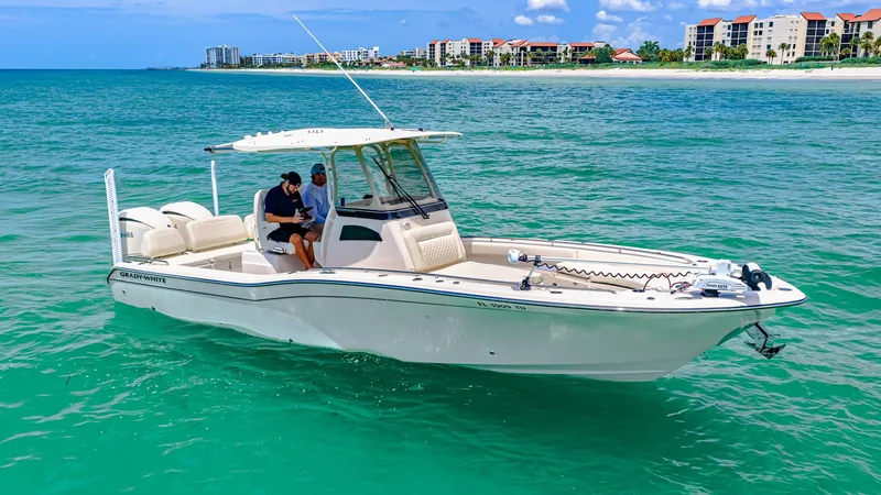 Slide: The Image of Grady-White 281 CE on Open Water The 2024 Grady-White 281 CE is elegantly showcased on serene turquoise waters. Featuring a spacious bow with ample seating, this model offers both comfort and functionality. The sleek helm area is equipped with state-of-the-art navigation and controls, pe - 7766855