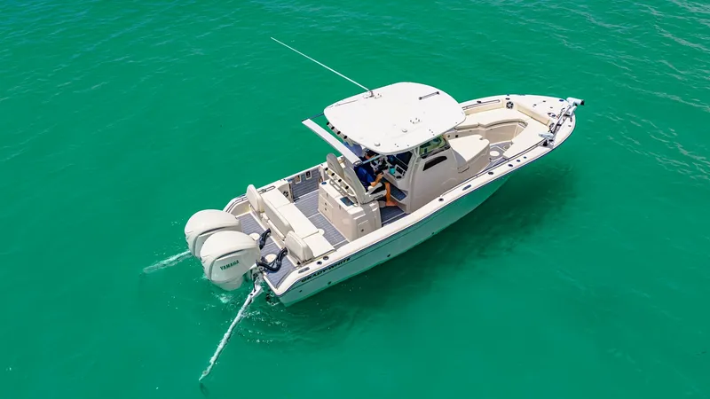 Slide: The Image of Aerial View of Grady-White 281 CE This aerial view showcases the sleek design of the 2024 Grady-White 281 CE. The vessel features a spacious aft deck with dual outboard engines, providing powerful performance on the water. The center console layout and elegant hardtop offer both functiona - 7766858