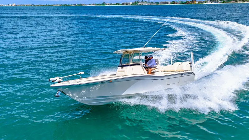 Slide: The Image of Grady-White 281 CE in Motion The 2024 Grady-White 281 CE is captured slicing through the vibrant blue waters, showcasing its sleek and powerful hull design. The center console layout is apparent, with a spacious helm and comfortable seating for passengers. This model exemplifies luxu - 7766904