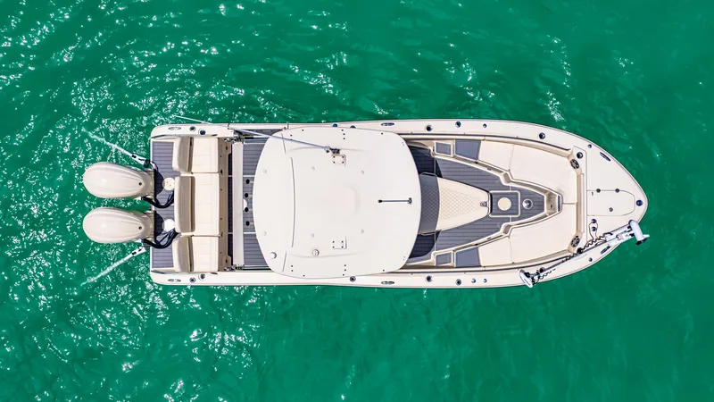 Slide: The Image of Aerial View of Grady-White 281 CE This top-down image showcases the sleek design of the 2024 Grady-White 281 CE. Highlighting its spacious deck layout, the boat features ample seating at the stern and a well-appointed helm area under a sturdy T-top. The twin outboard engines hint at the v - 7766860
