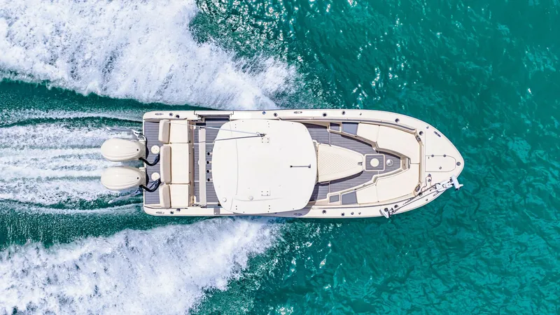 Slide: The Image of Aerial View of Grady-White 281 CE This aerial shot of the 2024 Grady-White 281 CE showcases its sleek design and efficient layout. The expansive deck offers ample seating and easy access to the dual outboard engines, ideal for both leisure and fishing. The vessel's streamlined hull cuts e - 7766900