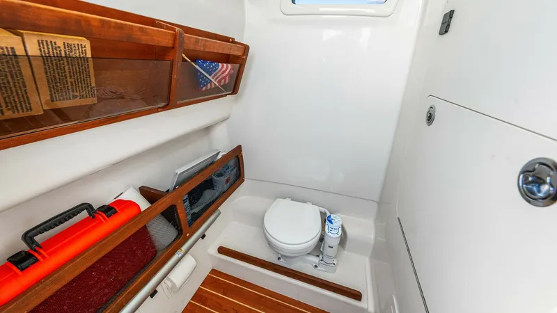 Slide: The Image of Compact Marine Head with Storage This 2024 Grady-White 281 CE features a well-designed marine head with a sleek, modern toilet and ample storage. The space is accented with warm wood finishes and a convenient overhead window for natural light. Ideal for comfort at sea, it combines functi - 7766896