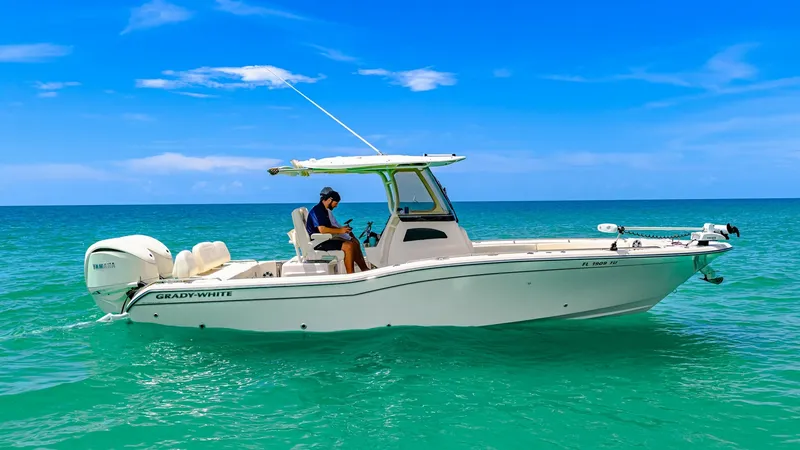 The Image of 2024 Grady-White 281 CE Side Profile of Grady-White 281 CE This image showcases the sleek side profile of the 2024 Grady-White 281 CE, gracefully navigating turquoise waters. The boat features a robust center console design with a hardtop for sun protection, equipped with a powerful outboard engine for impressive - 7766839