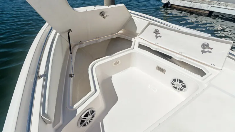 Slide: The Image of Spacious Bow Storage Area This image showcases the spacious bow storage area of the Zar Formenti 85 SL. The compartment is designed with ample room for storing gear, featuring secure latches and a clean, streamlined finish. The integrated speakers hint at a premium sound system, e - 7766830