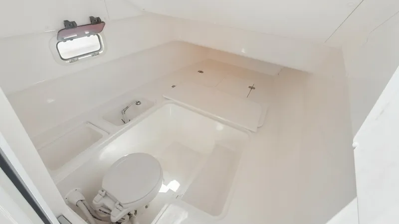 Slide: The Image of Spacious Cabin Bathroom This well-designed cabin bathroom features a compact marine toilet and integrated storage compartments, maximizing space efficiency. The bright interior and overhead lighting create a welcoming atmosphere, while the window offers natural light and ventila - 7766823
