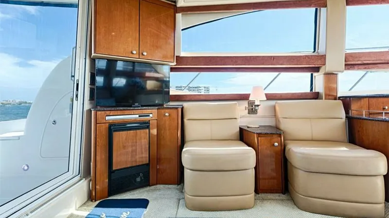 Slide: The Image of Salon with Seating and Entertainment Center The salon of the 2006 Meridian 391 Sedan features plush leather seating, offering comfort and style for relaxation or entertaining guests. Large windows provide expansive views and natural light, enhancing the inviting atmosphere. The entertainment center - 7766920