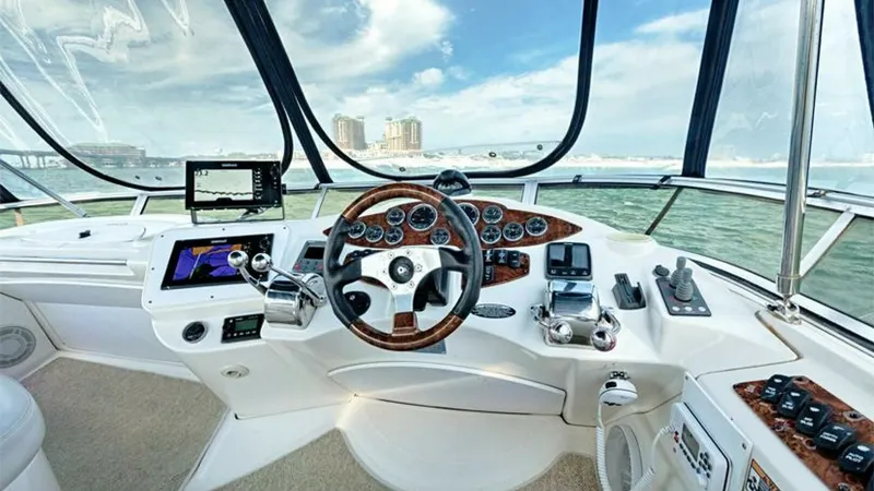 Slide: The Image of Helm Station with Panoramic Views The helm station of the 2006 Meridian 391 Sedan offers a commanding view with expansive windows, providing excellent visibility for navigation. The console is equipped with modern instrumentation and controls, featuring a classic wood-trimmed steering whe - 7766932