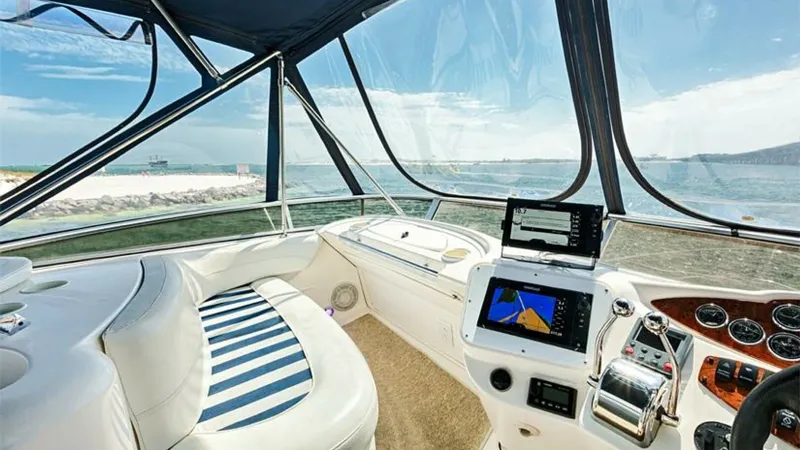 Slide: The Image of Flybridge Helm Station with Seating The 2006 Meridian 391 Sedan's flybridge helm offers a panoramic view, enhanced by clear wraparound windshields. The helm station is equipped with modern navigation electronics, ensuring precise control and effortless cruising. Plush seating with striped c - 7766937