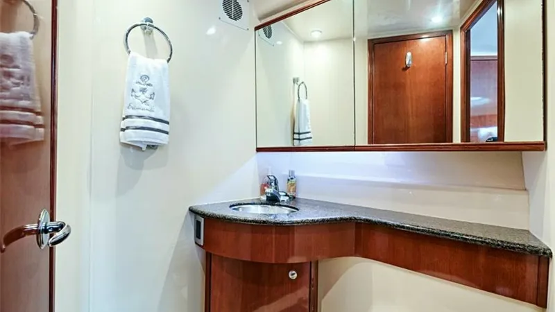 Slide: The Image of Elegant Bathroom with Vanity The bathroom of the 2006 Meridian 391 Sedan features a sleek vanity with a polished granite countertop, providing ample space for toiletries. Warm wood cabinetry complements the contemporary design, while a large mirrored cabinet enhances the room's spaci - 7766927