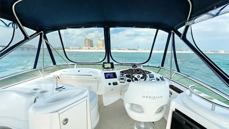 Slide: The Image of Flybridge Helm with Panoramic Views This 2006 Meridian 391 Sedan's flybridge helm offers expansive panoramic views, ideal for navigating coastal waters. Featuring a plush captain's chair and an ergonomic dashboard with modern navigation equipment, this area is designed for both comfort and - 7766933