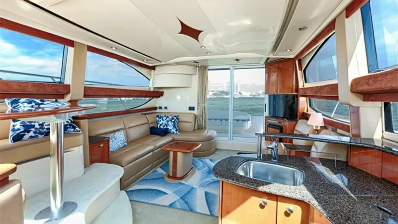 Slide: The Image of Spacious Salon with Panoramic Windows The salon of this 2006 Meridian 391 Sedan offers a luxurious and inviting space, featuring expansive panoramic windows that flood the area with natural light. Plush seating and a sleek table provide comfort and style, while the well-appointed kitchenette - 7766921