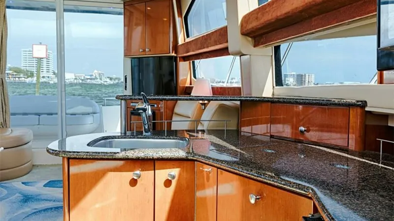 Slide: The Image of Spacious Galley with Ocean Views The galley of the 2006 Meridian 391 Sedan is elegantly designed with polished wood cabinetry and sleek granite countertops, offering ample space for meal preparation. Large windows provide abundant natural light and stunning ocean views, creating a bright - 7766923