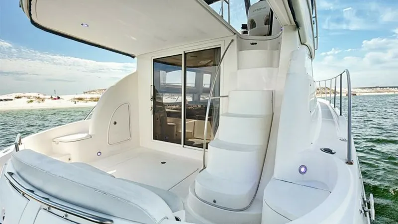 Slide: The Image of Aft Deck with Access to Flybridge This image showcases the aft deck of the 2006 Meridian 391 Sedan, featuring sleek, curved seating and easy access to the flybridge via a molded staircase. The spacious area provides a comfortable setting for outdoor relaxation or entertaining, enhanced by - 7766943