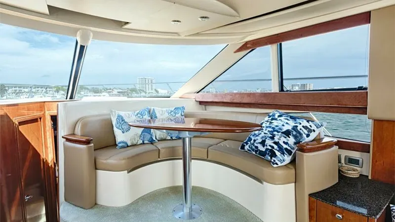 Slide: The Image of Flybridge Seating Area with Panoramic Views This inviting flybridge seating area on the 2006 Meridian 391 Sedan features plush, curved seating with a stylish wooden table, perfect for entertaining or enjoying the scenic views. Large windows flood the space with natural light, enhancing the airy amb - 7766925